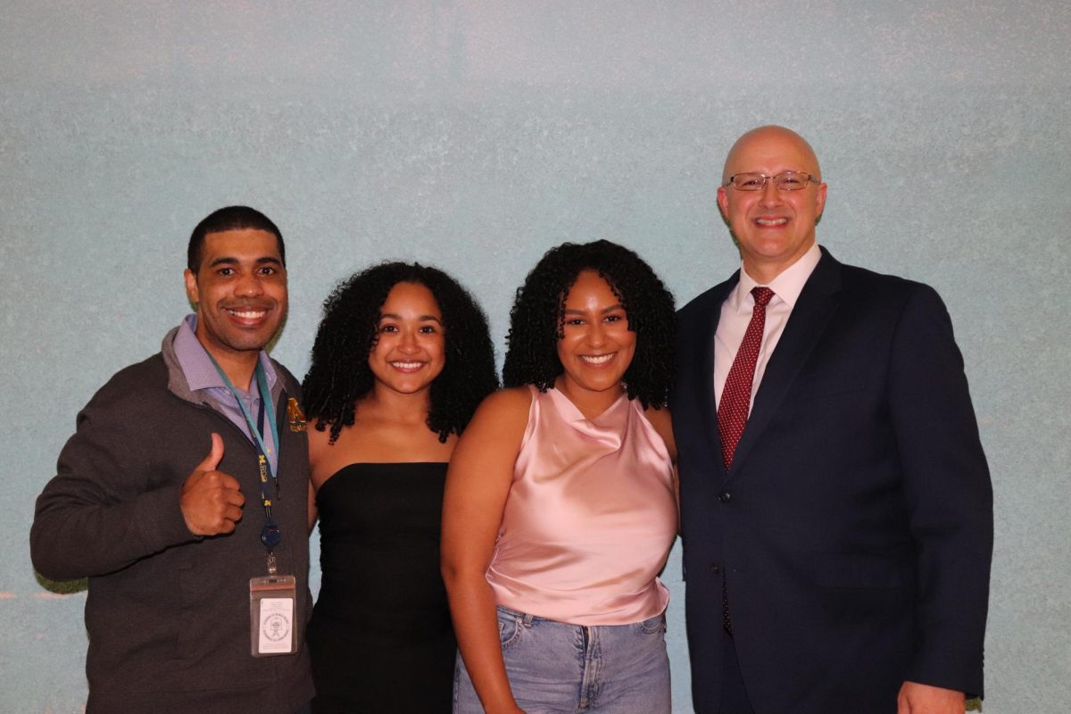 Principal Mr. Sigerson (right) with TCA alumni Arkey Barnett, Genessy Rodriguez and Cristal Herrera. (left to right)