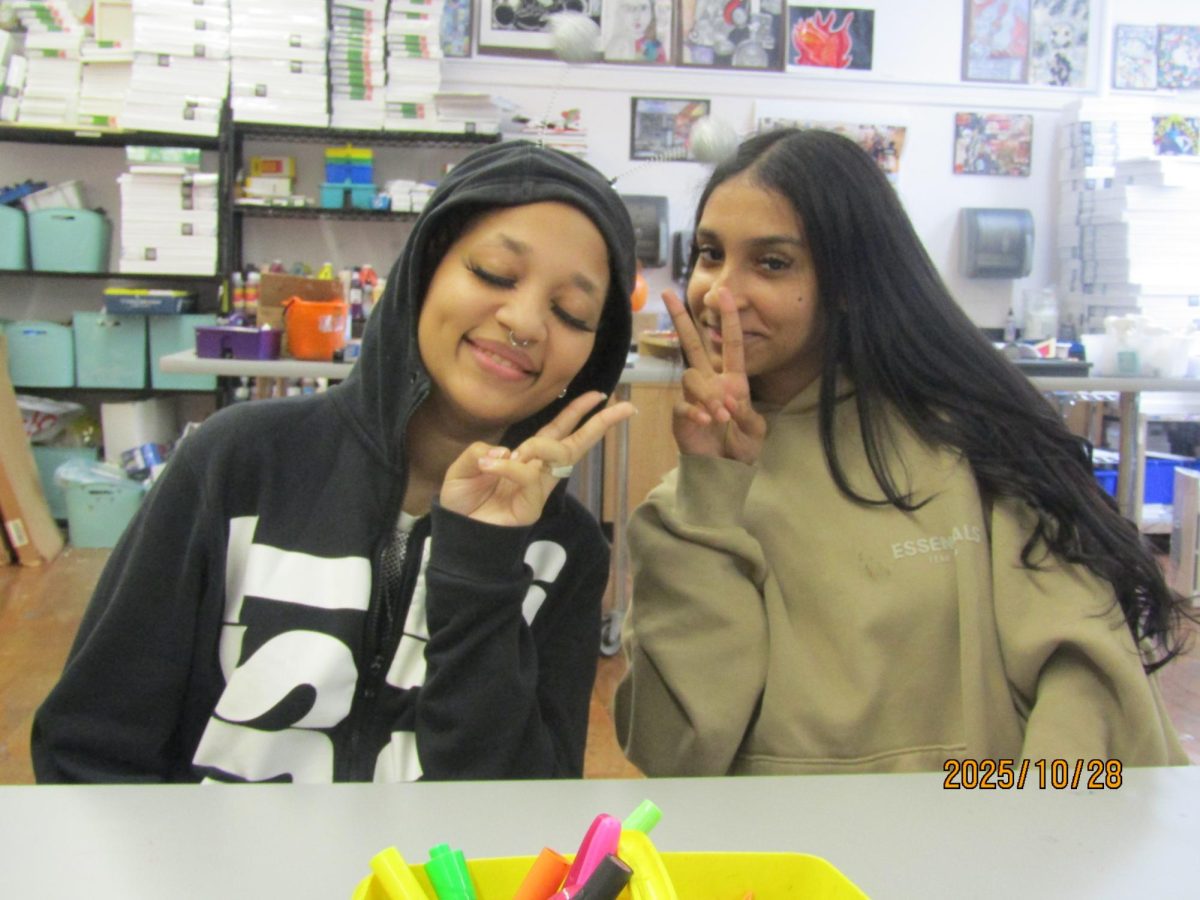 Artist Mia Carrassco (left) sitting with fellow artist Delany Caro