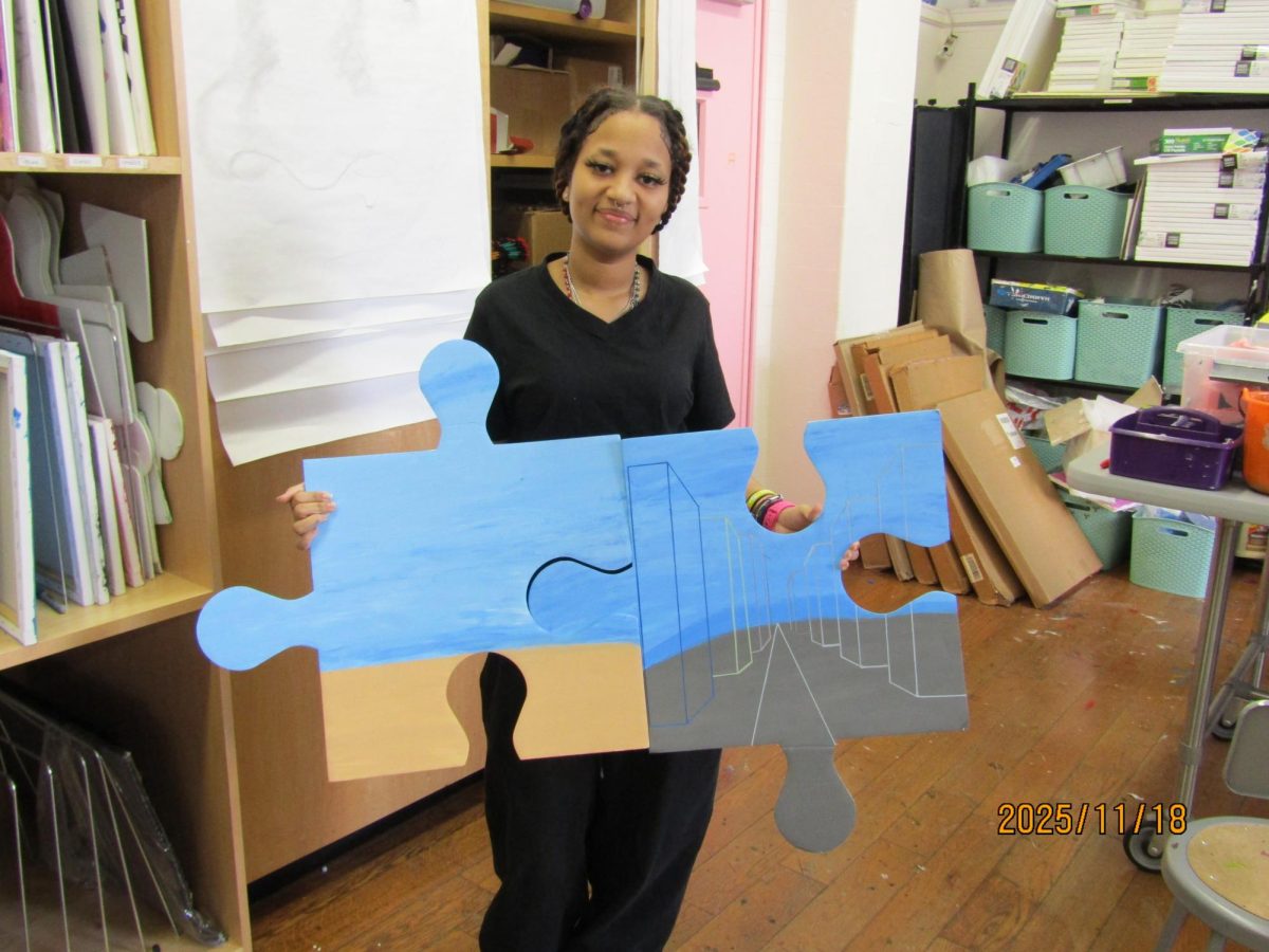 Artist Mia Carrassco holding her newest project art about her background.